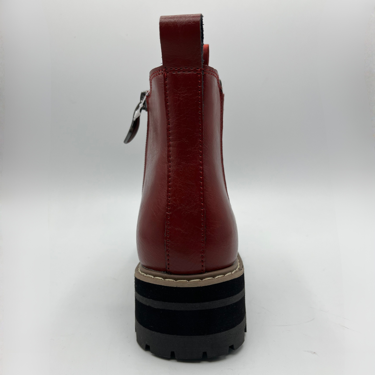 Red leather boot with a black sole on a white background