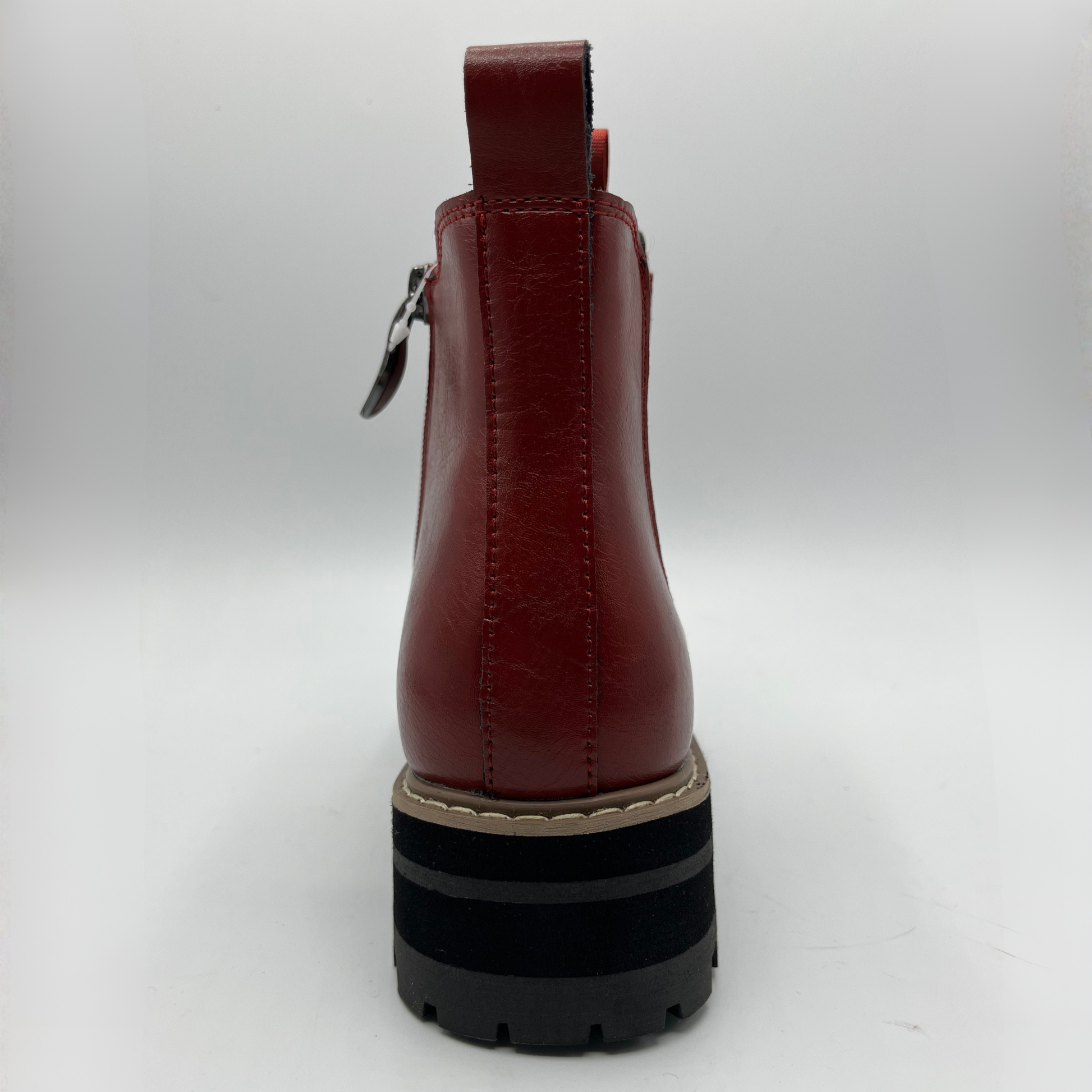 Red leather boot with a black sole on a white background