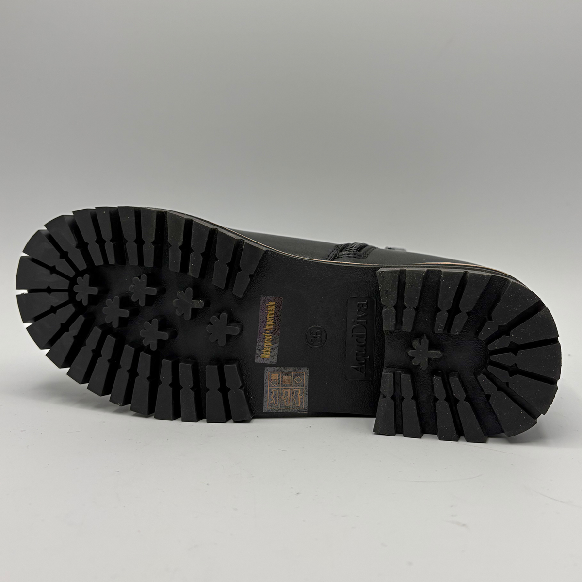 Bottom view of a black chelsea boot with an elastic side gore