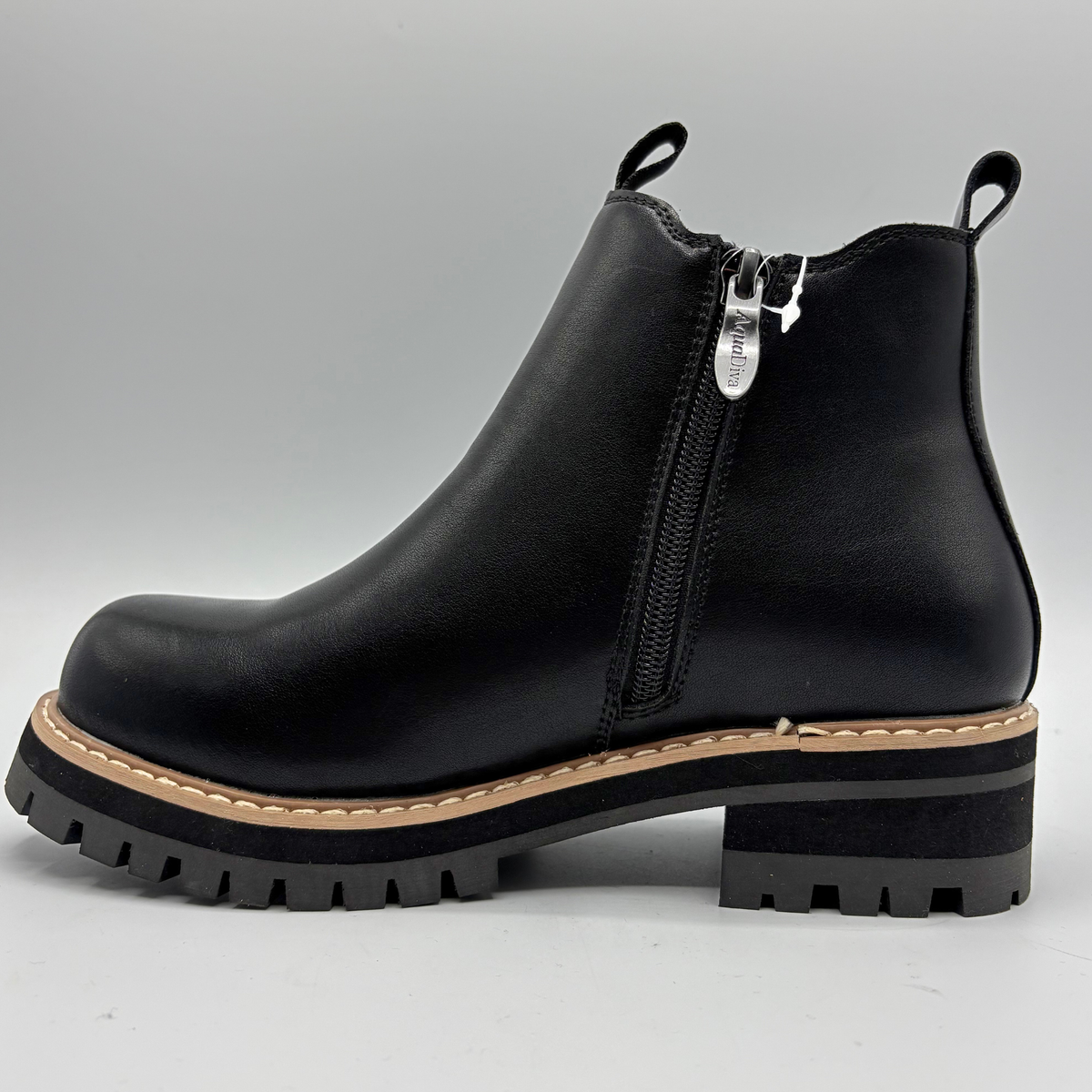 Left facing view of a black chelsea boot with an elastic side gore