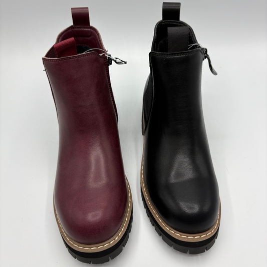 Top view of a pair of chelsea boots both with a side zipper closure. One is black and the other is plum
