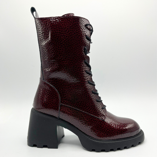 Maroon lace-up boot with a chunky black sole on a white background