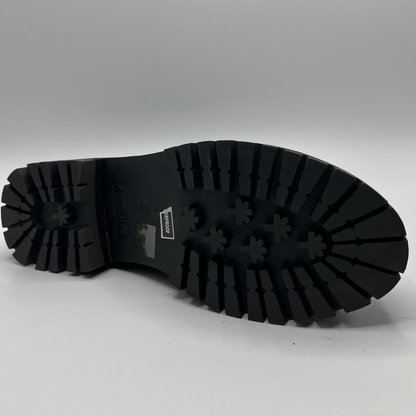 Black rubber sole of a shoe on a gray background