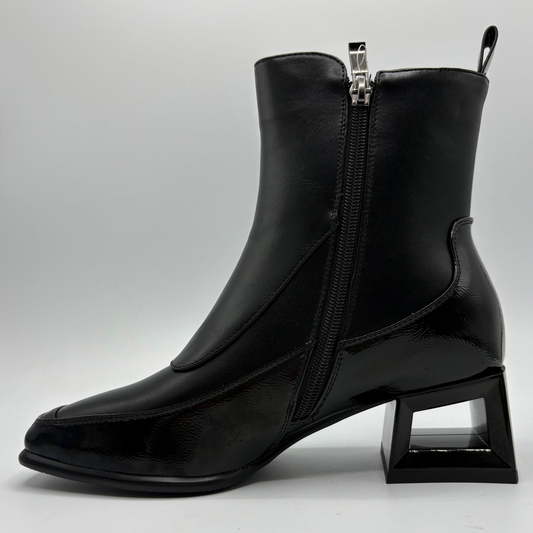 Left facing view of a black boot with a cut out block heel and round button details