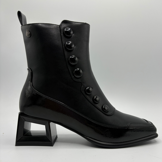 Right facing view of a black boot with a cut out block heel and round button details