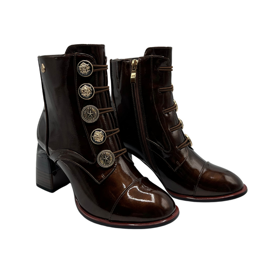 45 degree angled view of a pair of patent leather short boots with antique style buttons, side zipper closure, block heel and rounded toe.
