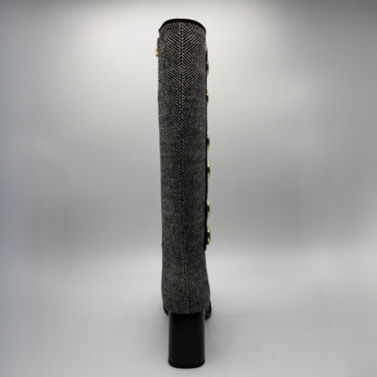 Back view of a tweed patterned tall boot with large black and gold buttons and a block heel