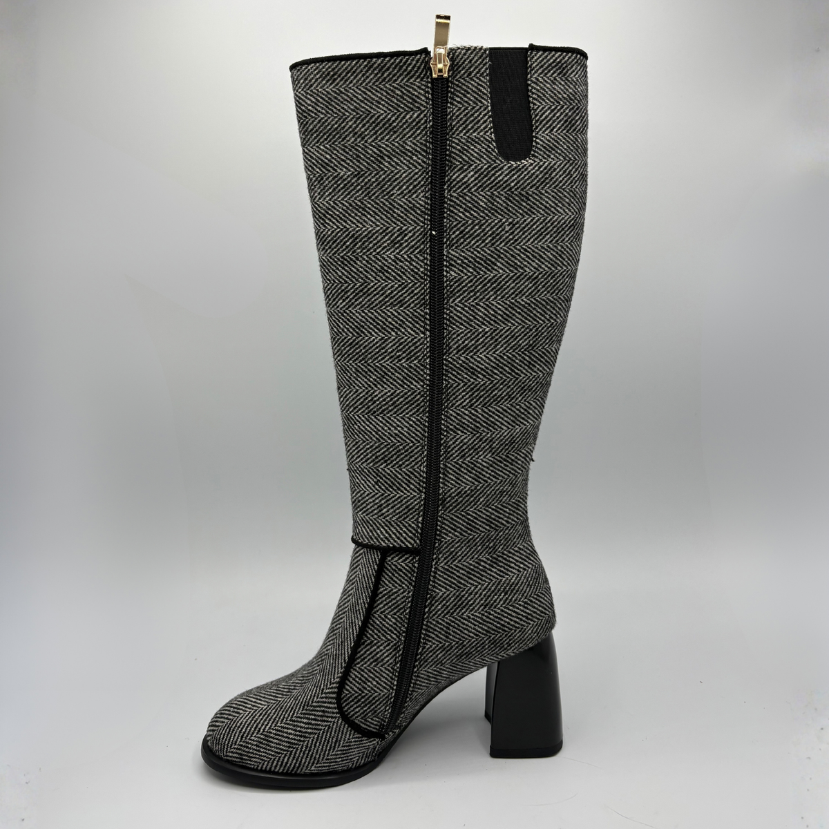 Left facing view of a tweed patterned tall boot with a side zipper and a block heel