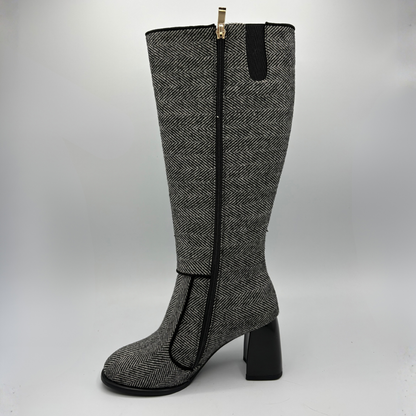 Left facing view of a tweed patterned tall boot with a side zipper and a block heel