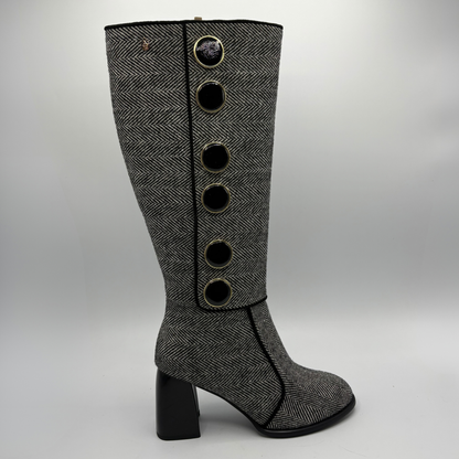 Right facing view of a tweed patterned tall boot with large black and gold buttons and a block heel