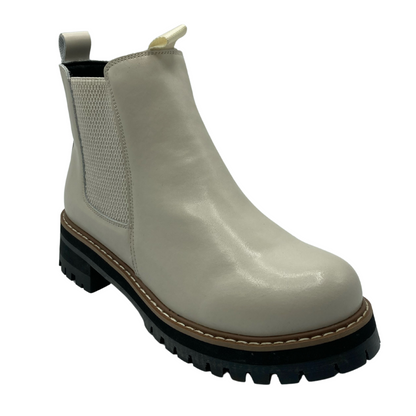 45 degree angled view of beige leather ankle boot with elastic side gore and black rubber sole