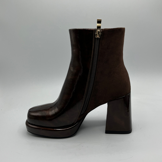 Brown ankle boot with a platform sole on a gray background