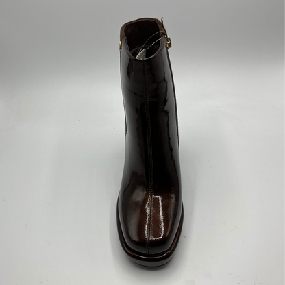 Shiny brown ankle boot on a light gray background
