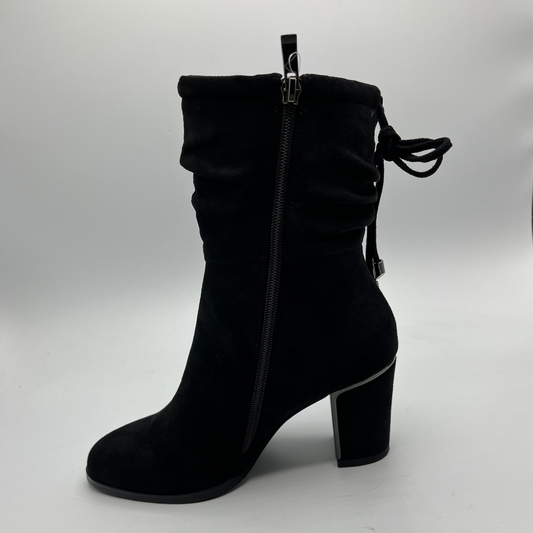 Black suede ankle boot with a block heel on a light gray background