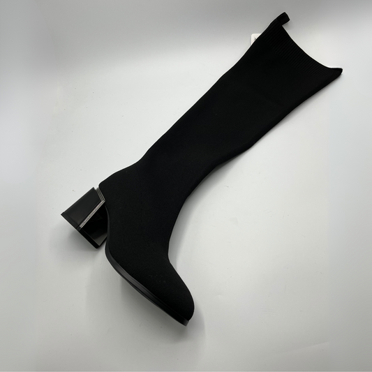 Black knee-high boot on a light gray background
