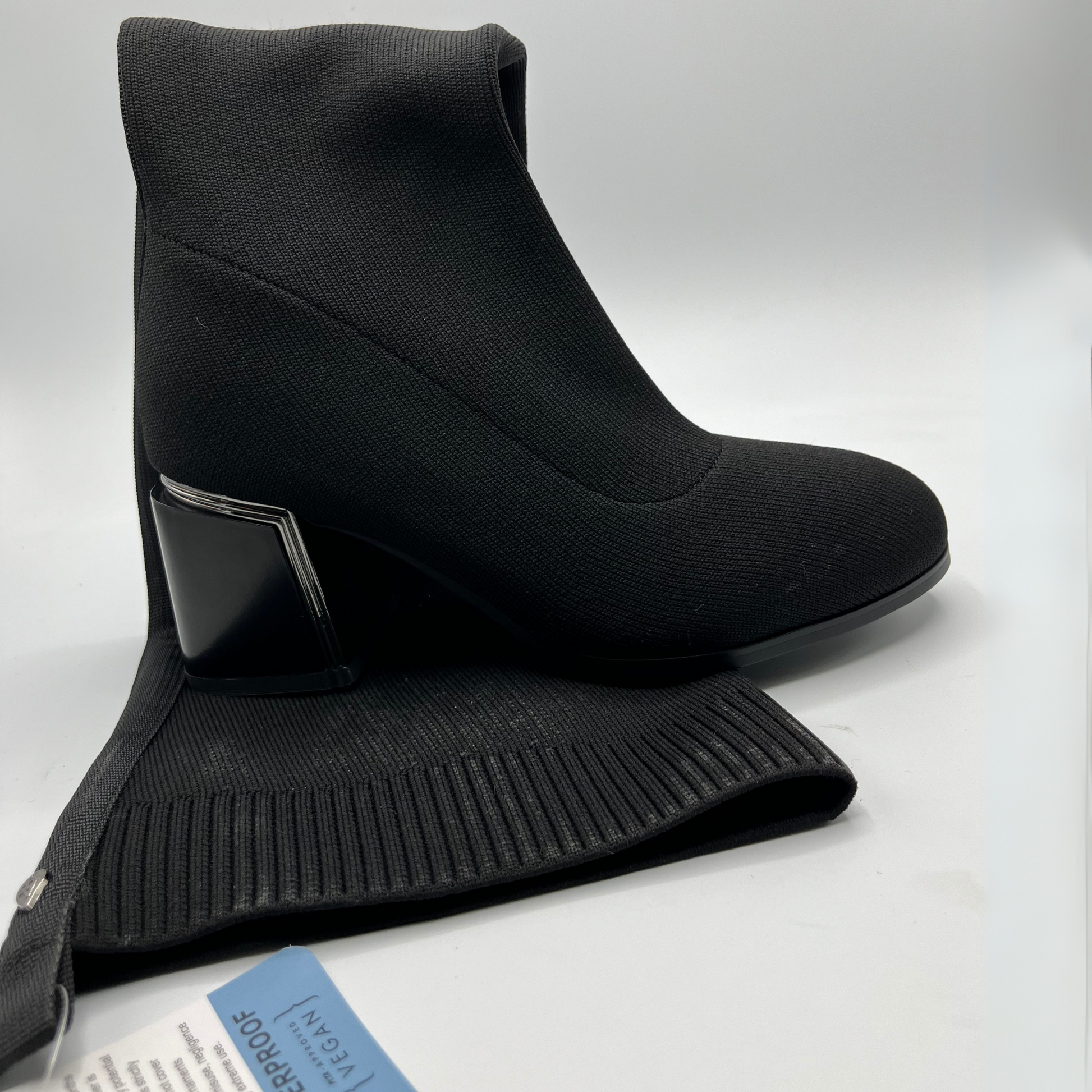 Black tall boot on a light gray background