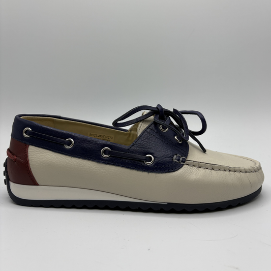 Navy and beige boat shoe on a gray background