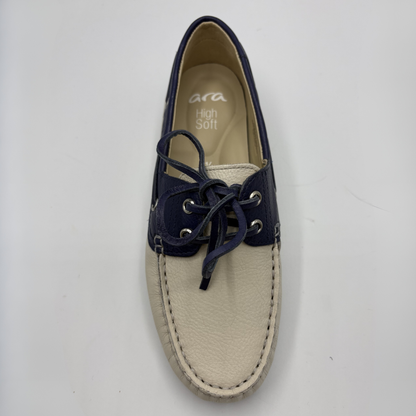 Beige boat shoe with navy laces on a white background