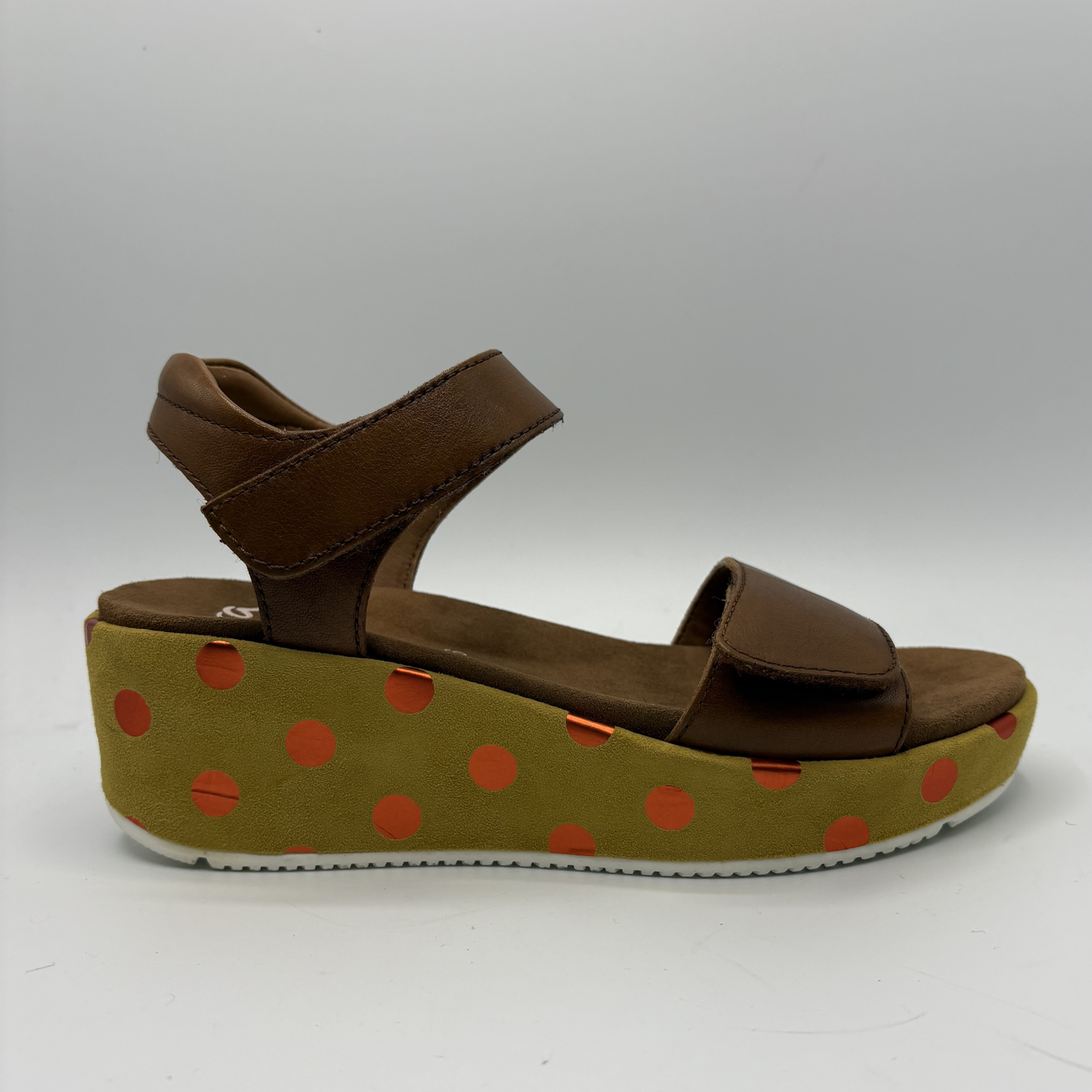 Brown sandal with a polka dot platform on a white background