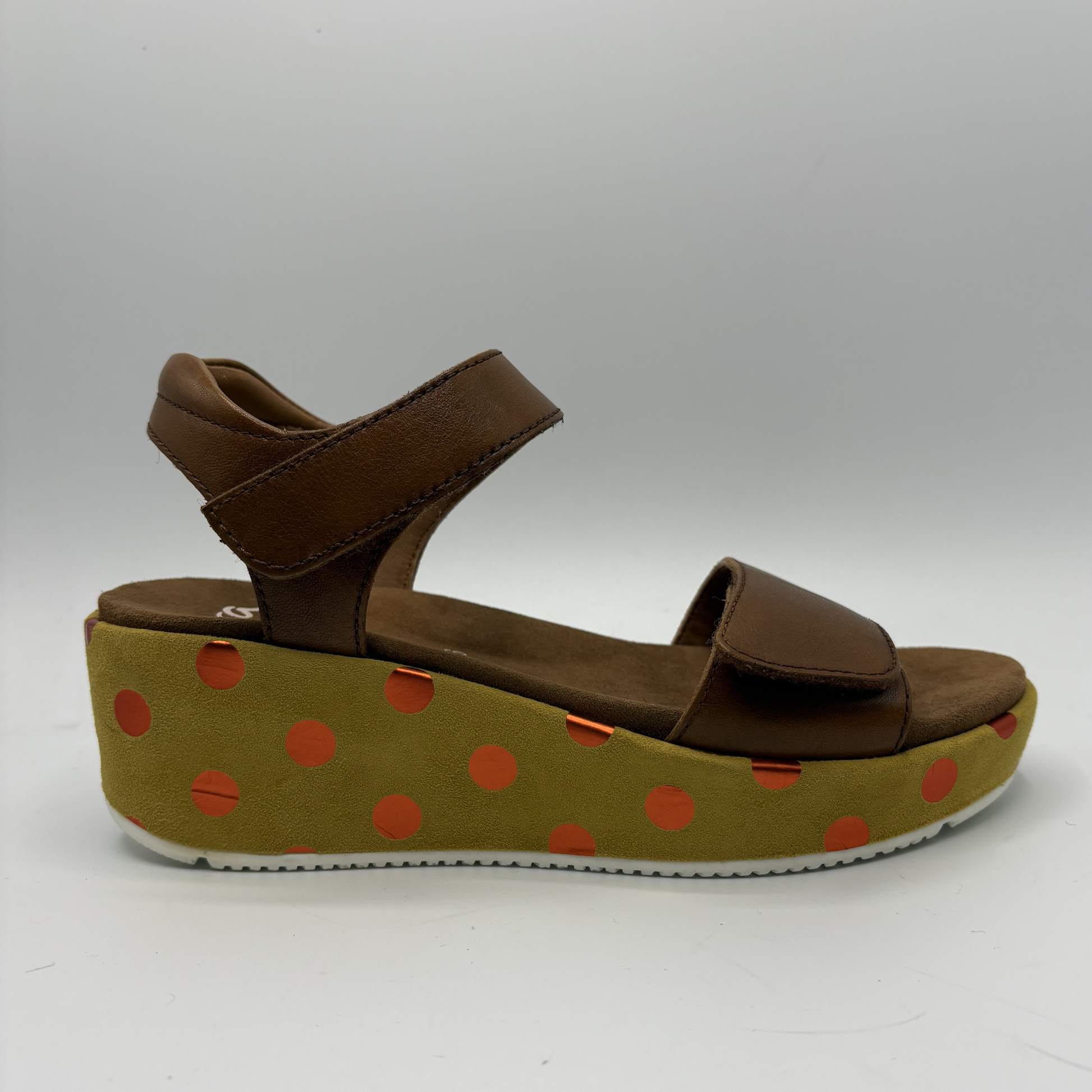 Brown sandal with a polka dot platform on a white background