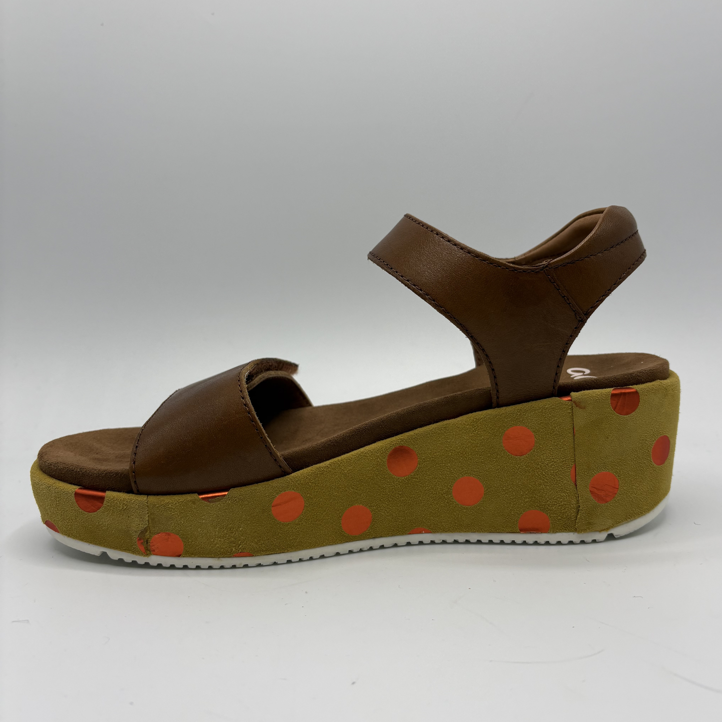 Brown sandal with a polka dot platform on a white background