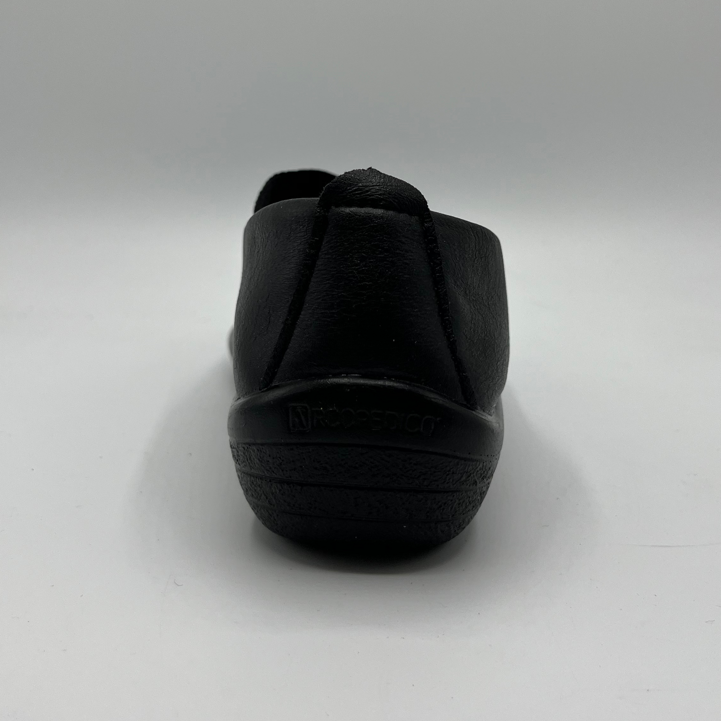 Black slip-on shoe on a light gray background