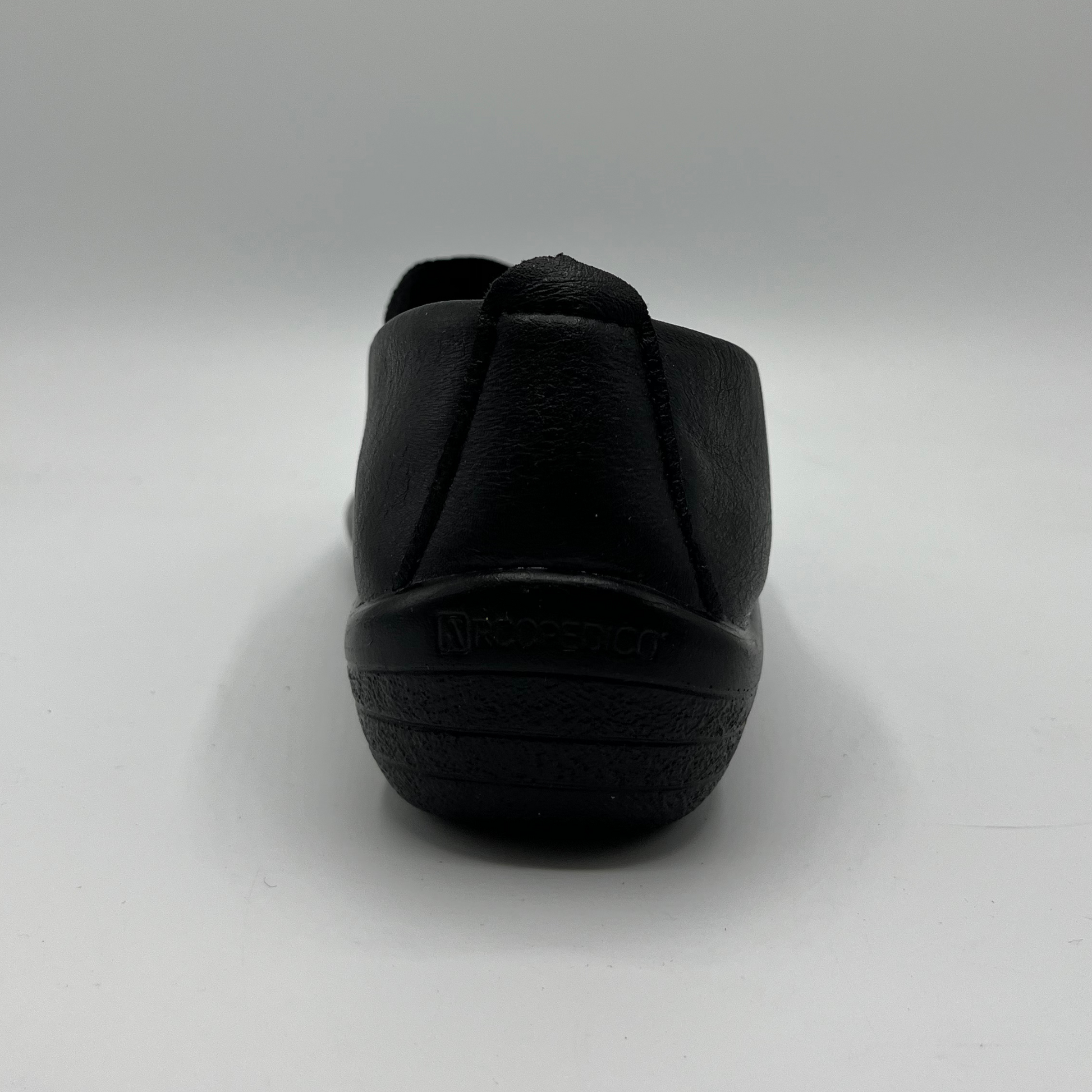 Black slip-on shoe on a light gray background