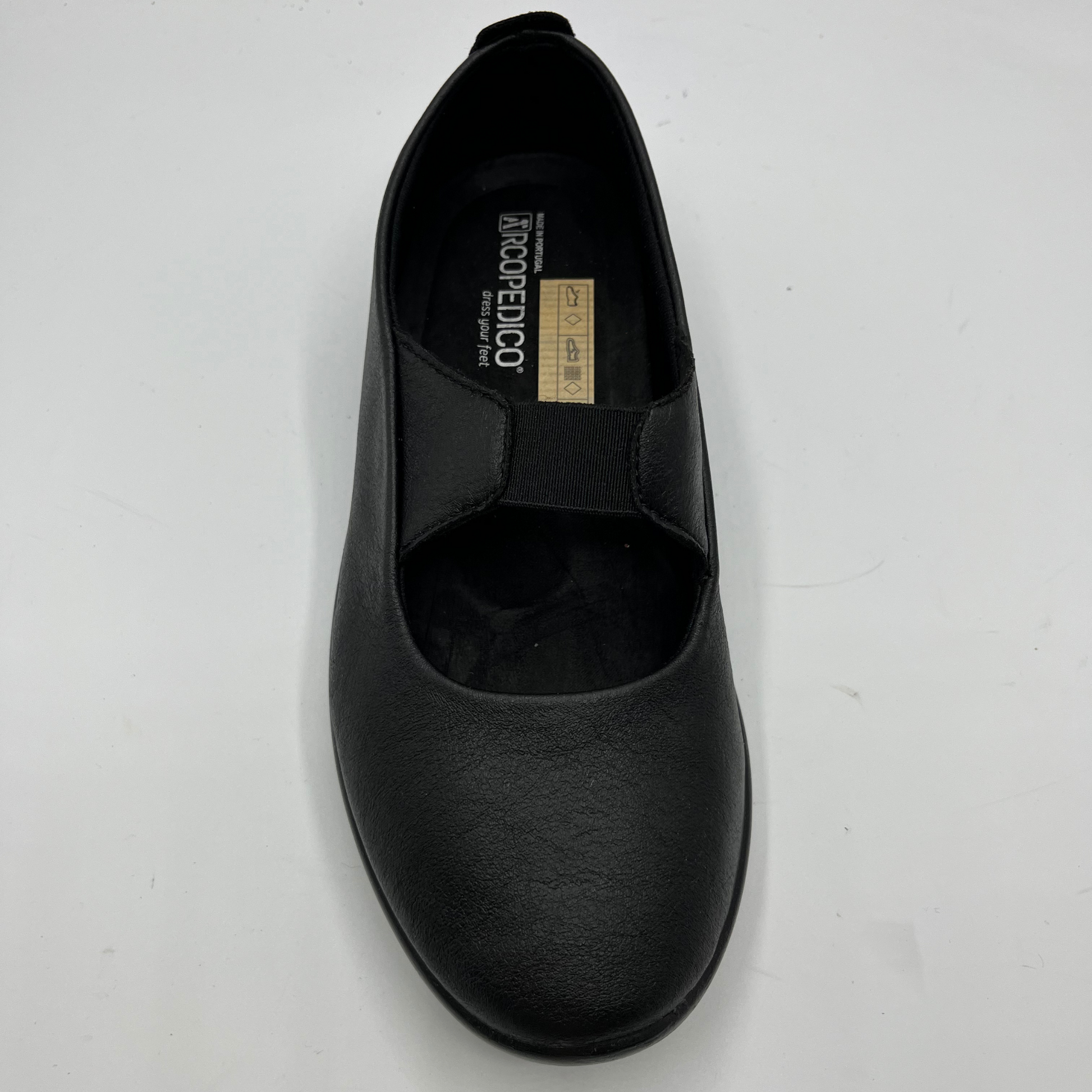 Top view of a black slip on shoe with an elasticated strap