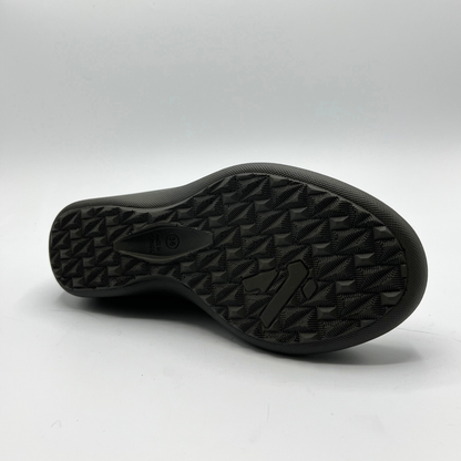 Close-up of a black shoe sole on a light gray background