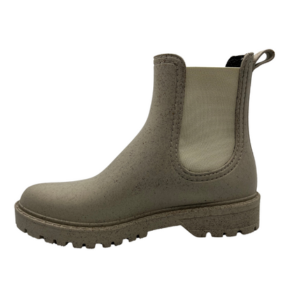 Left facing view of natural beige coloured short boot with elasticated side gores, pull on heel tab and rubber outsole