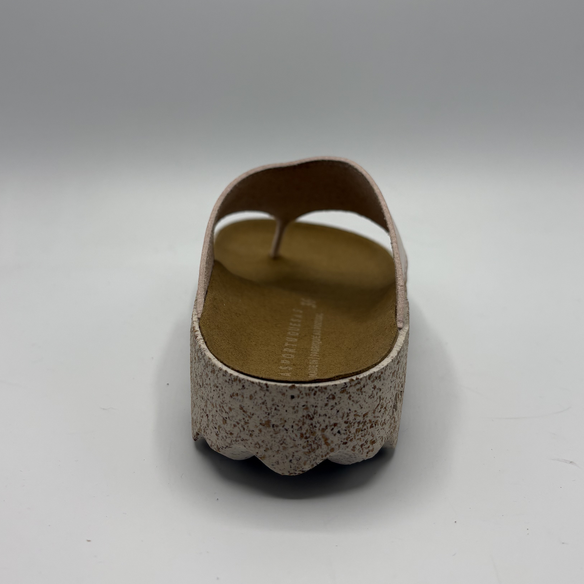 Brown sandal with textured sole on a white background