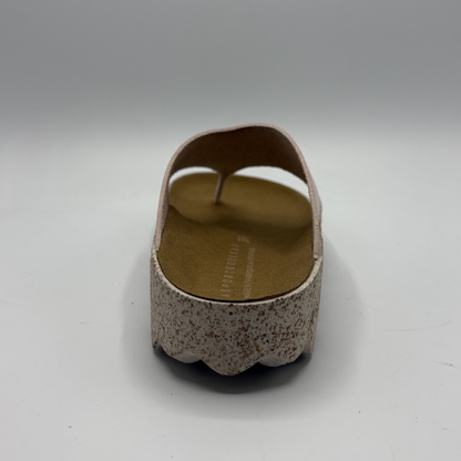 Brown sandal with textured sole on a white background