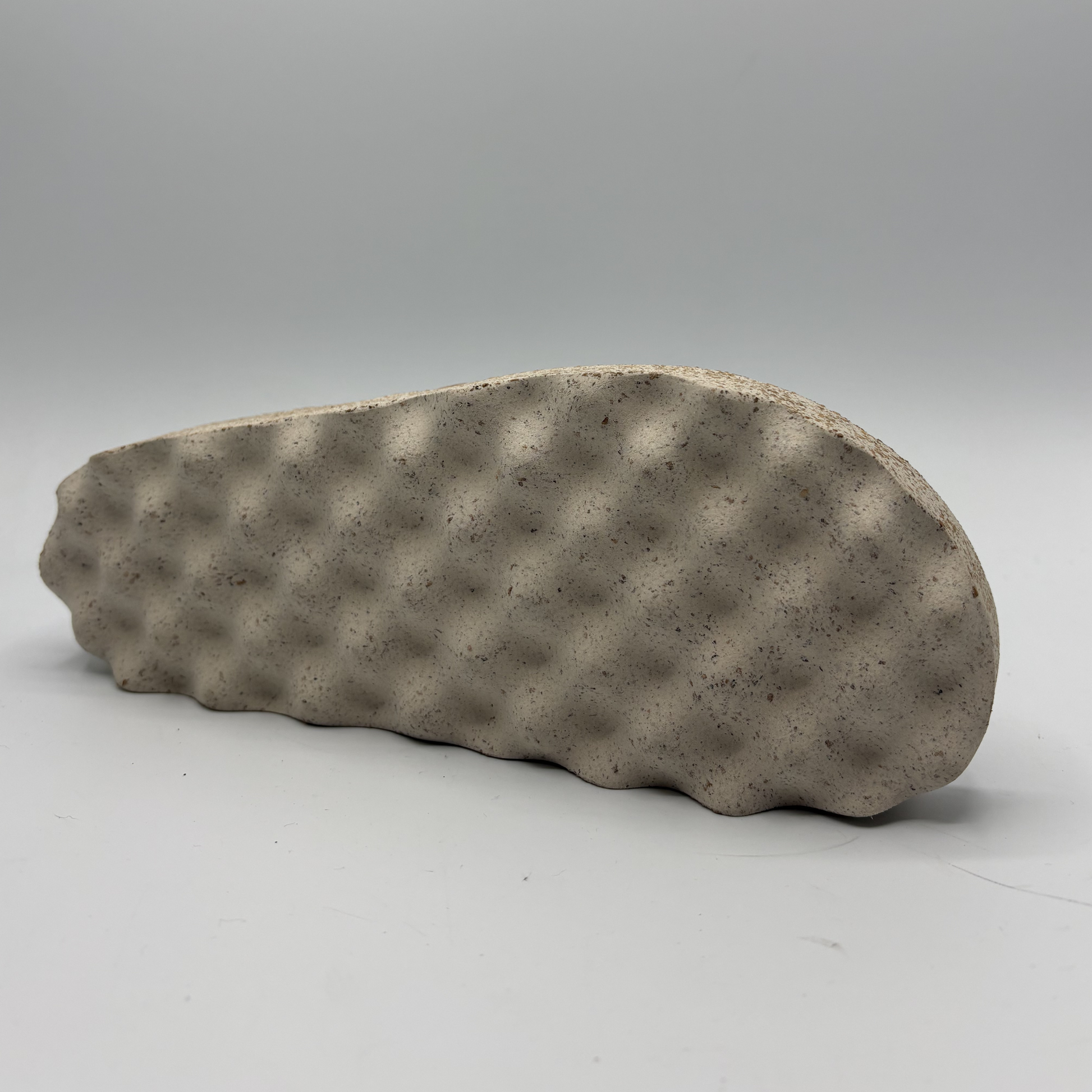 Textured sandal outsole on a gray background