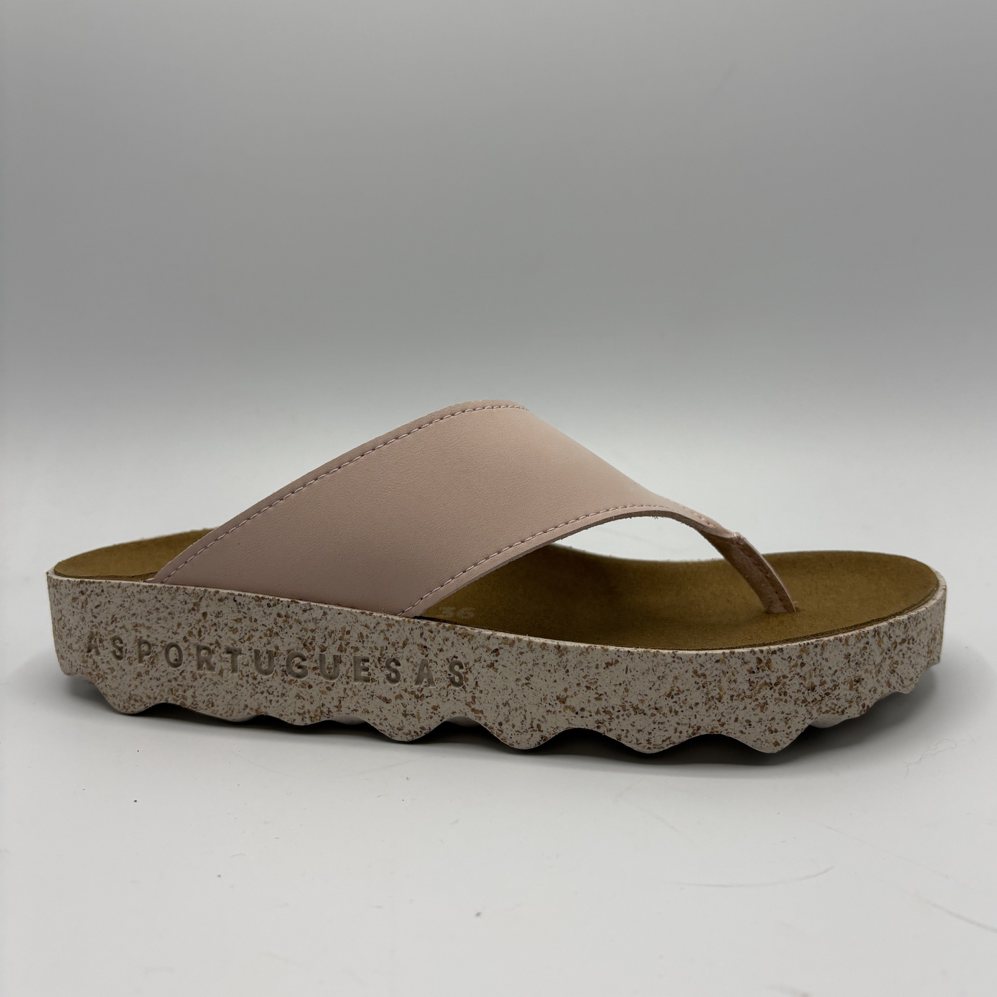 Pink sandal with speckled sole on a white background