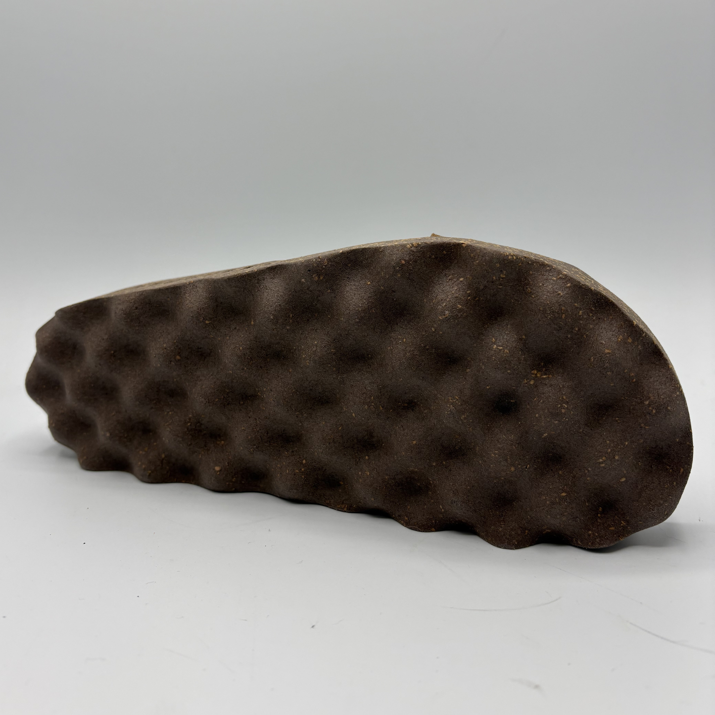 Brown textured sandal sole on a gray background