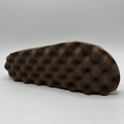 Brown textured sandal sole on a gray background