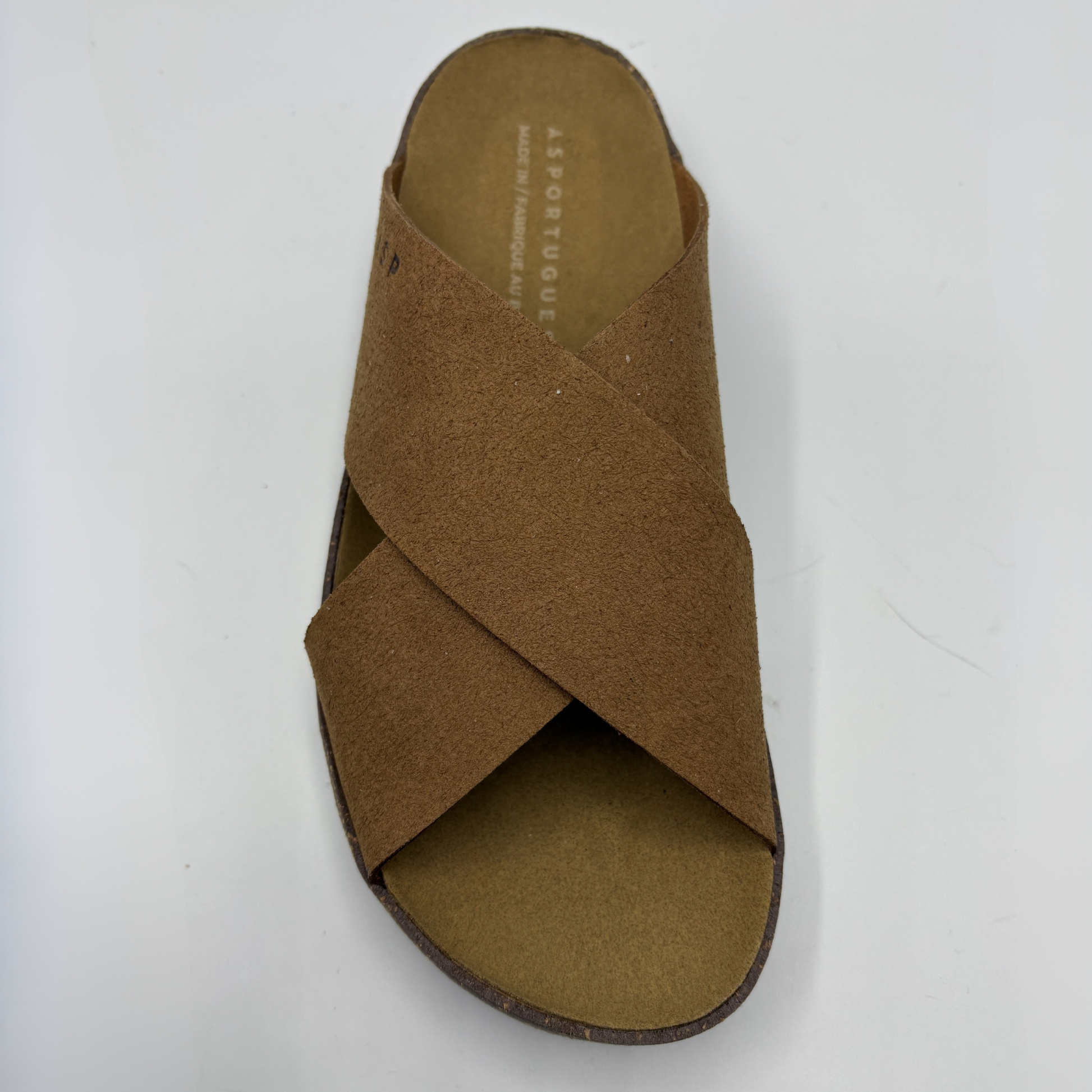 Brown sandal with criss-cross strap design on a white background