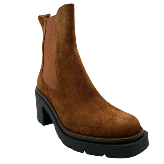 45 degree angled view of tan suede short boot with black rubber outsole and block heel