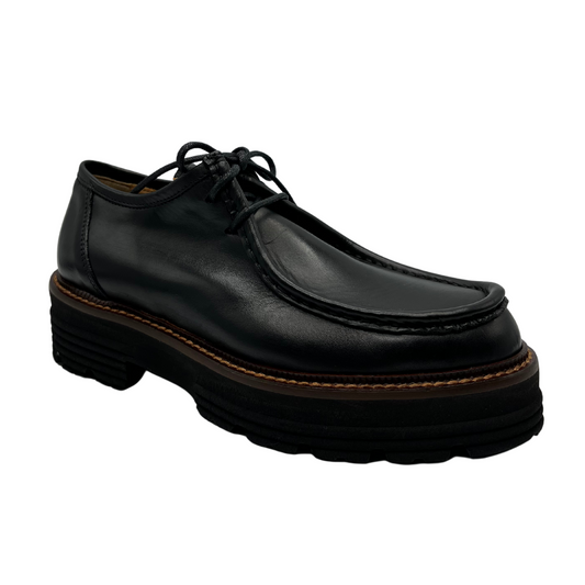 45 degree angled view of black leather loafer with thick black outsole and leather lining