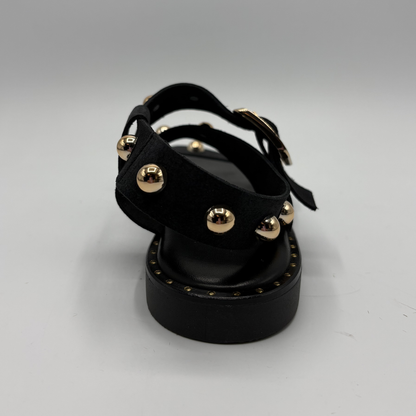 Black sandal with gold studs on a white background