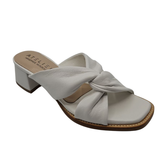 45 degree angled view of white leather sandals with a soft square toe. These heels have a leather lining and leather wrapped block heel. Knotted straps on upper