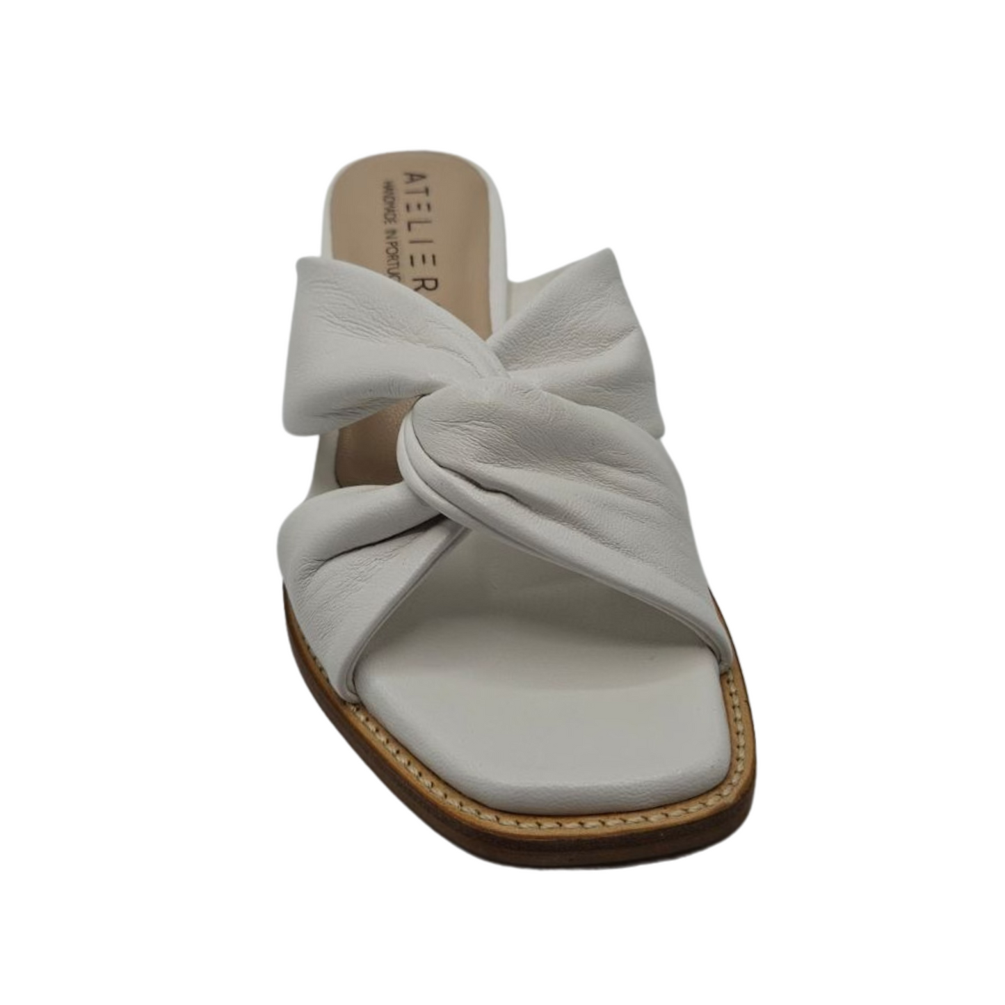 Front view of white leather sandals with a soft square toe. These heels have a leather lining and leather wrapped block heel. Knotted straps on upper