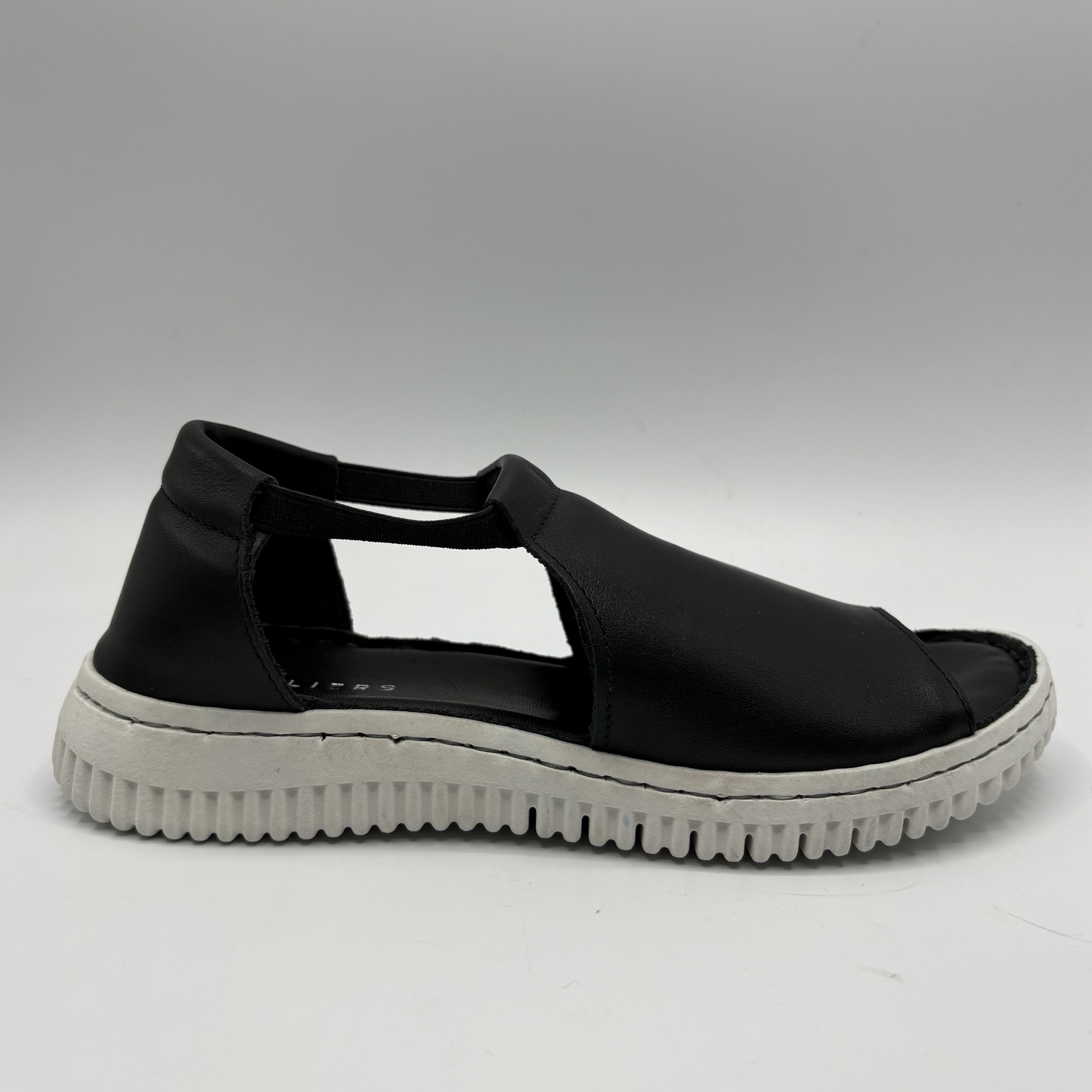Black sandal with a white sole on a gray background