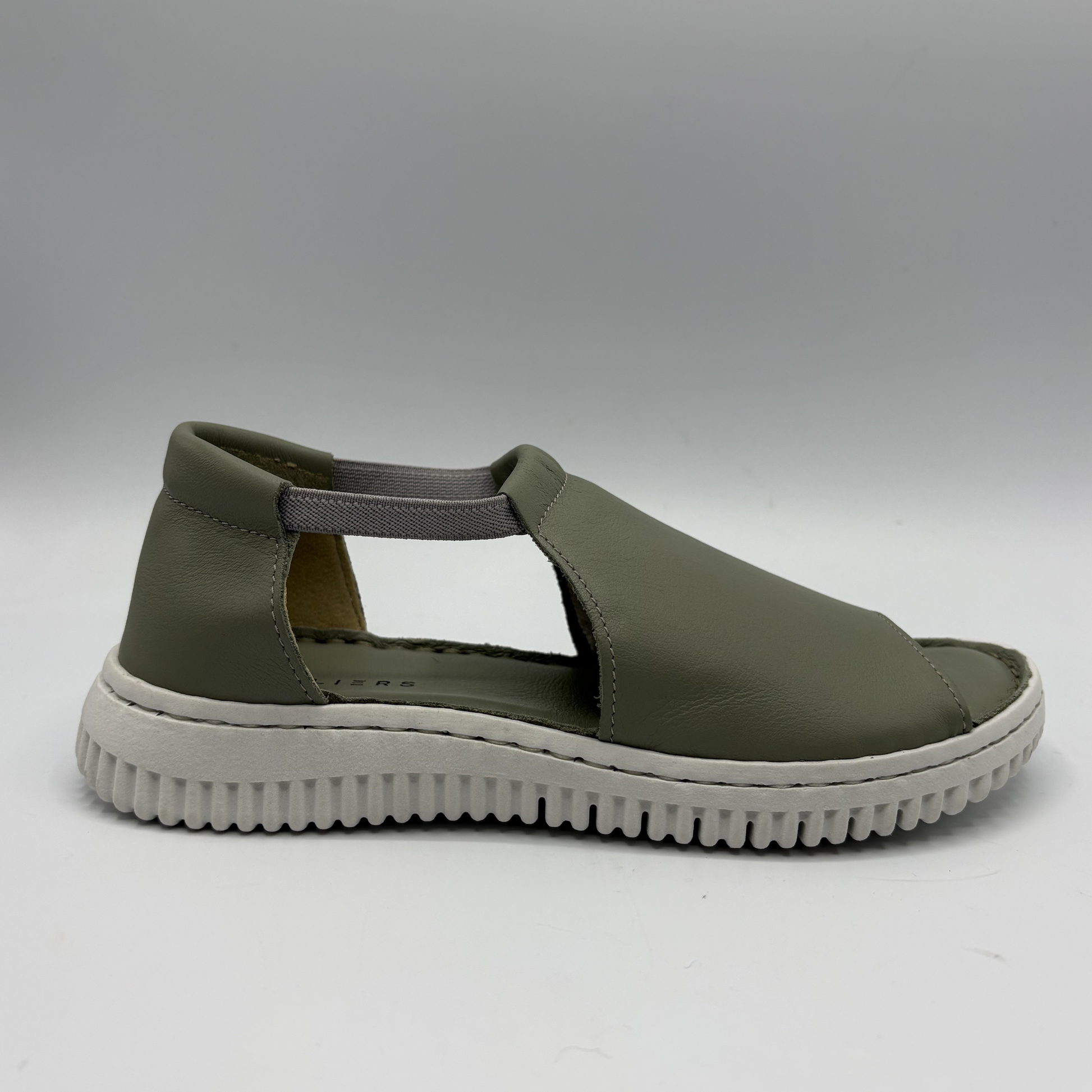 Green sandal with a white sole on a gray background
