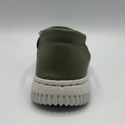 Green slip-on shoe with white sole on a light gray background