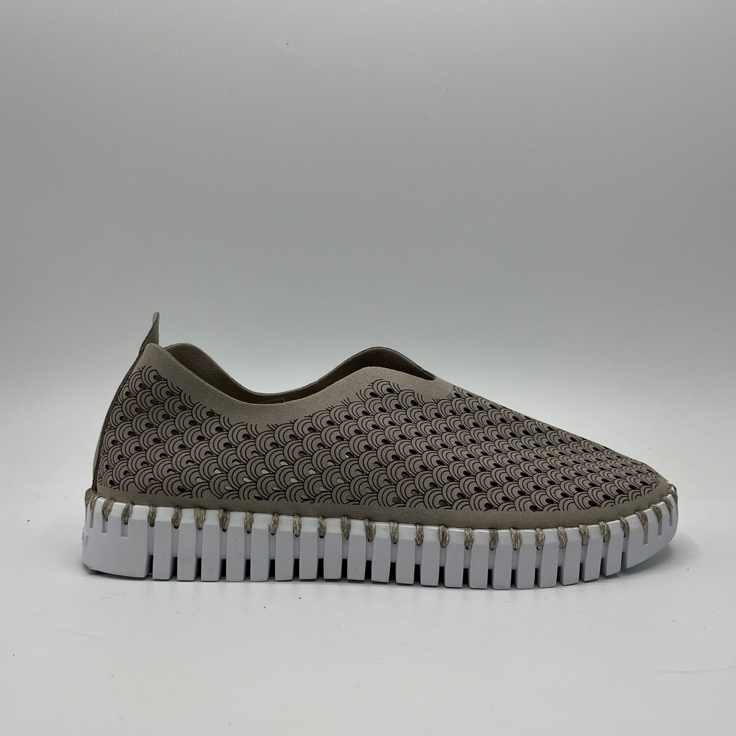 Right facing view of atmosphere taupe coloured slip on shoe with an intricate laser cut upper and white rubber outsole.