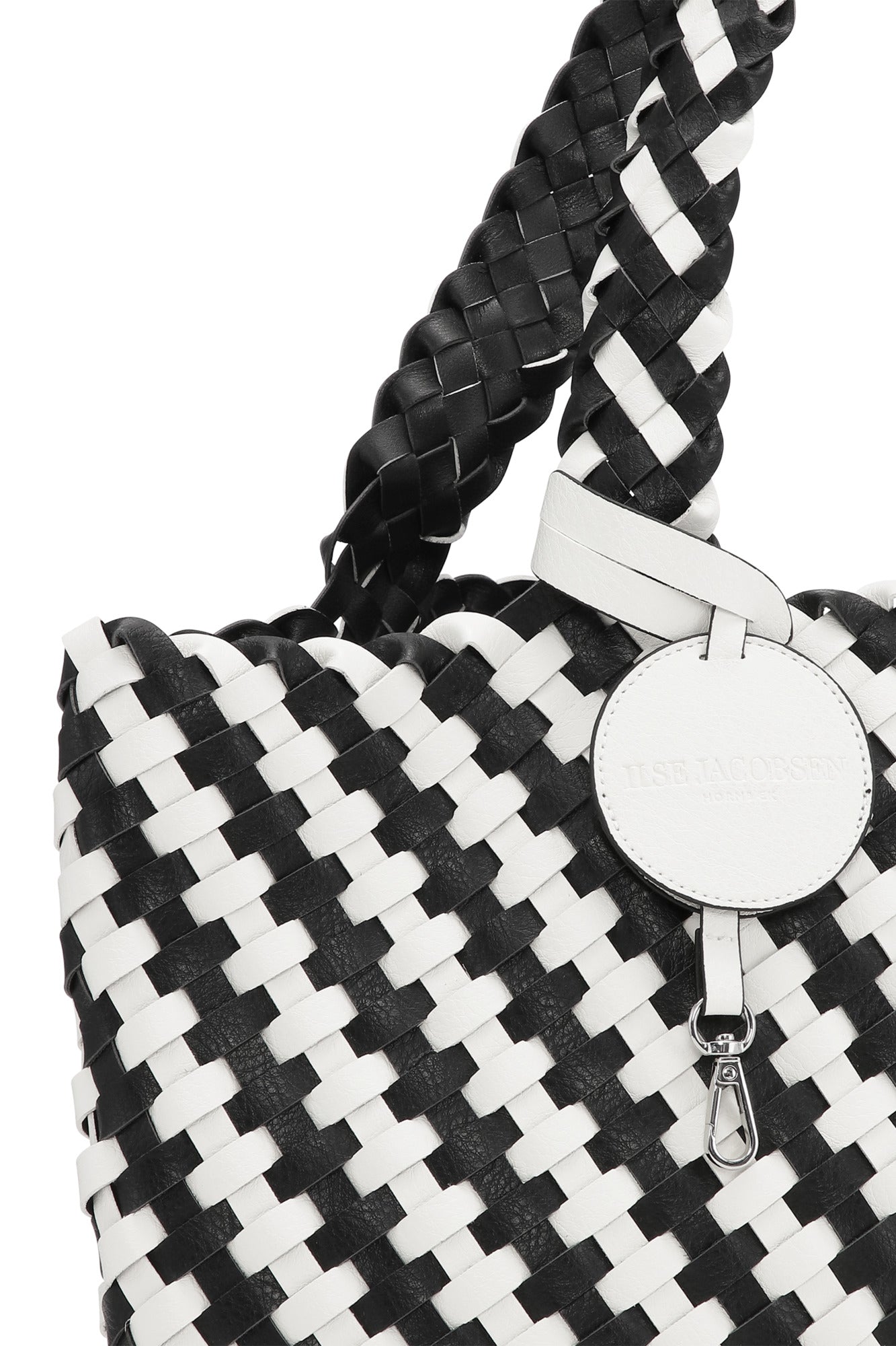 Black and white woven handbag with braided handle on a white background