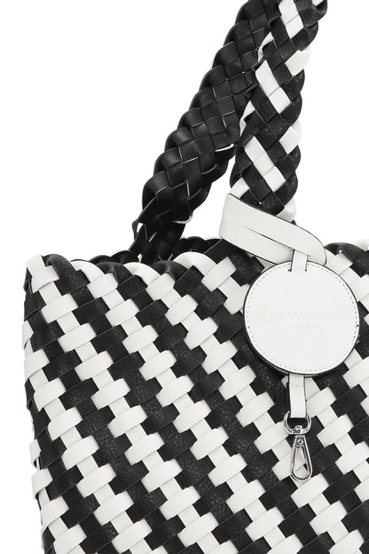 Black and white woven handbag with braided handle on a white background