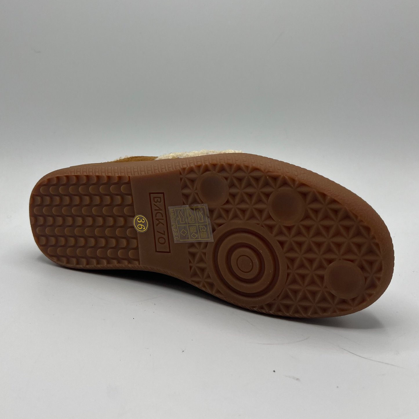 Brown sole of a shoe with a visible brand logo on a white background