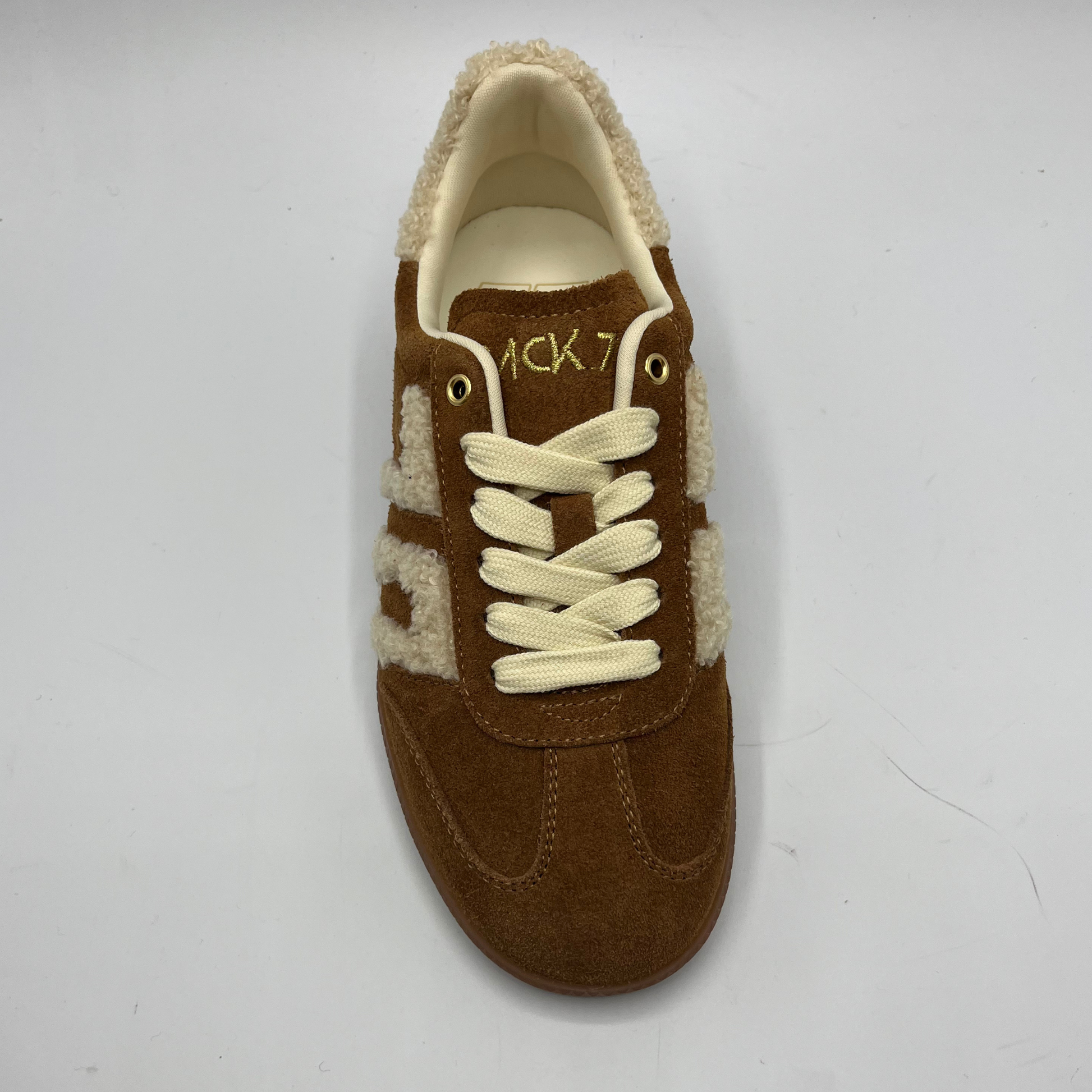 Brown sneaker with cream laces on a white background